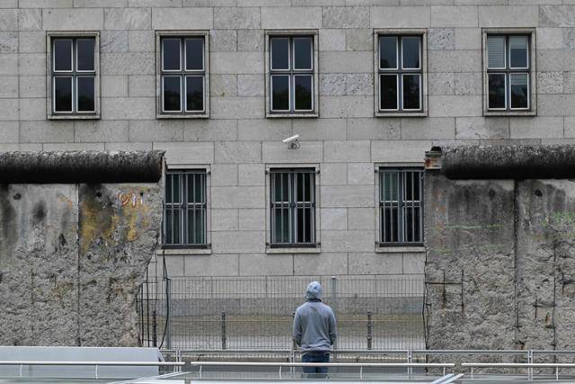 독일 통일 34주년을 맞은 3일 베를린에서 한 시민이 일부분이 남아 있는 베를린 장벽을 바라보고 있다. 베를린=AFP 연합뉴스