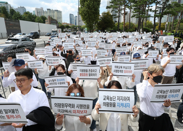 ▲ 의대교수들이 3일 오후 서울 용산구 대통령실 인근에서 열린 한국의학교육평가원 무력화 저지 결의대회에서 손팻말을 들고 구호를 외치고 있다. 연합뉴스