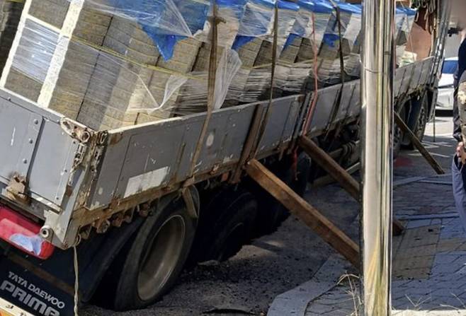 A 25-ton truck lies in the sinkhole that opened up in Incheon on Friday. [INCHEON FIRE SERVICES]