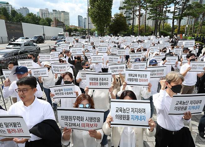 의대교수들이 3일 오후 서울 용산구 대통령실 인근에서 열린 한국의학교육평가원 무력화 저지 결의대회에서 손팻말을 들고 구호를 외치고 있다. 연합뉴스