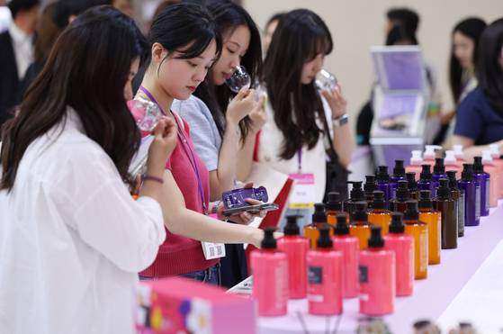 올해 5월 서울 강남구 코엑스에서 열린 화장품 박람회인 ‘코스모뷰티서울’에서 관람객들이 한 인디브랜드 전시장에서 진열된 화장품을 살펴보고 있다. [뉴시스]
