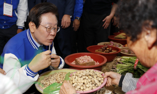 이재명 더불어민주당 대표가 5일 낮 인천 강화군 강화풍물시장에서 땅콩을 구매하고 있다. 이날 이 대표는 2024 하반기 재·보궐선거 강화군수에 출마한 한연희 후보의 지지를 호소했다. 뉴시스