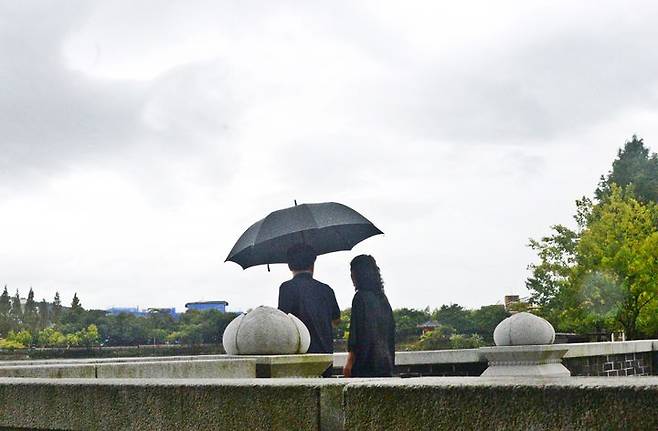 [전주=뉴시스] 김얼 기자 = 전북 전주덕진공원을 찾은 시민들이 우산으로 비를 피하며 산책을 하고 있다. 2024.09.20. pmkeul@newsis.com *재판매 및 DB 금지