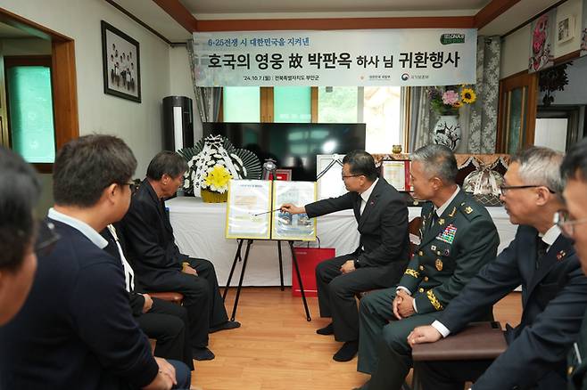 이근원 국방부유해발굴감식단장이 24일 전라북도 부안군에 있는 유가족 자택에서 고(故) 박판옥 하사의 ‘호국의 영웅 귀환 행사’를 열고 유족에게 고인의 참전 과정과 유해발굴 경과를 설명하고 있다. 국방부 제공