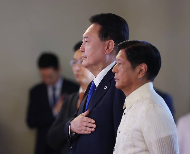 President Yoon Suk Yeol (second from right) salutes to the national flag as he stands beside Philippine President Ferdinand Marcos Jr. (right) during an official reception ceremony held at Malacanang Palace in Manila, the Philippines, on Monday. (Yonhap)