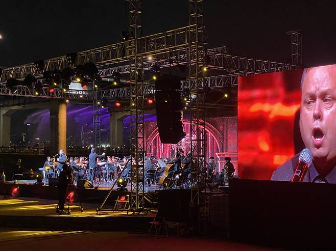 Paul Potts performs on stage, with his image displayed on a large screen at the Wellness Seoul Concert held at Sebitseom Banpo Hangang Park, Seoul, Sunday. (Hwang Joo-young/The Korea Herald)