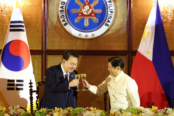 Korean President Yoon Suk Yeol, left, and his Filipino counterpart, Ferdinand Marcos Jr., toast during a state luncheon at Malacanang Palace in Manila on Monday. [JOINT PRESS CORPS]