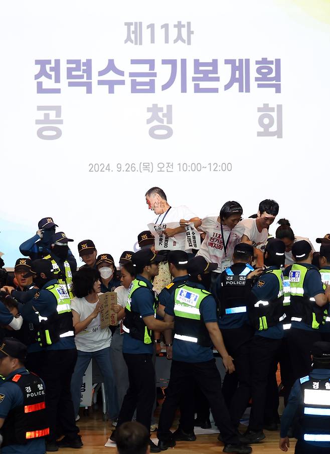 기후활동가와 환경운동가들이 11차 전력수급기본계획 공청회 시작에 앞서 “핵발전소 수명연장, 신규건설 결사반대” 등을 외치다가 경찰에 연행되고 있다. /연합뉴스