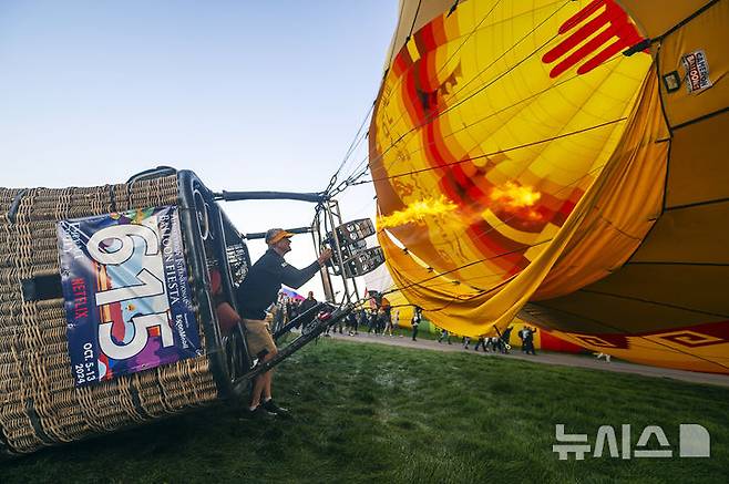 [앨버커키( 미 뉴멕시코주)=AP/뉴시스] 미국 뉴멕시코주 앨버커키 시에서 10월 5일 부터 열린 제 52회 국제앨버커키 풍선축제에서 대형 열기구 조종사 브래드 라이스가 7일 대형 열기구의 이륙을 준비하고 있다. 2024.10.08.