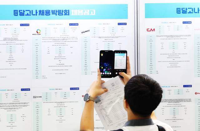 한 학생이 지난달 10일 오전 경기도 수원시 권선구 수원메쎄에서 열린 '2024 달고나(달콤한 고졸취업 나도할래) 채용박람회'에서 채용 게시물을 사진으로 찍고 있다. 연합뉴스