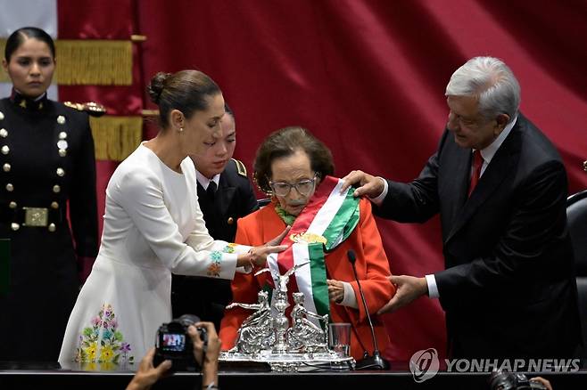 지난 1일(현지시간) 멕시코 대통령 취임식에서 어깨띠 건네주는 이피헤니아 마르티네스 하원 의장(가운데)  [AFP 연합뉴스 자료사진. 재판매 및 DB 금지]