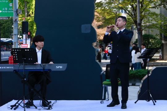 태광그룹이 '문화의 달'을 맞아 10일 서울 광화문 흥국생명빌딩에서 '해머링맨 가을 음악회'의 첫 번째 공연을 개최했다. 일주학술문화재단 장학생 출신이자 '리코더 마스터' 남형주가 흥국생명빌딩 입구 '해머링맨' 앞에 마련된 야외무대에서 연주하고 있다. [태광그룹 제공]