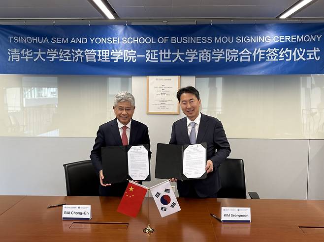 Bai Chong-En, dean of Tsinghua University's School of Economics and Management, left, and Kim Seong-moon, dean of Yonsei University's Graduate School of Business, pose for a photo after signing a memorandum of understanding on Thursday. [YONSEI UNIVERSITY]