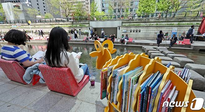 서울야외도서관 운영 첫날인 4월18일 서울 종로구 청계천 마련된 '책 읽는 맑은냇가'를 찾은 시민들이 독서를 즐기고 있다.  2024.4.18/뉴스1 ⓒ News1 장수영 기자