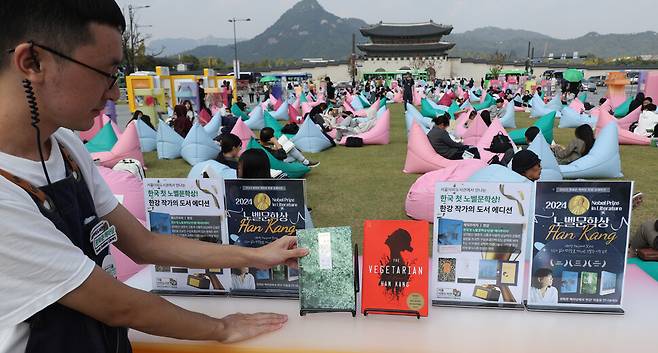 서울 광화문광장 책마당 행사장에 11일 오후 관계자가 노벨문학상을 수상한 작가 한강의 책을 놓고 있다. 연합뉴스