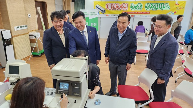 8일 충남 예산군 대흥면 ‘619 대흥역’에서 열린 농촌 왕진버스 행사에서 백남성 충남세종농협본부장(왼쪽부터), 최재구 예산군수, 지종진 조합장, 황기훈 NH농협 예산군지부장이 눈 검사를 받는 한 주민을 살펴보고 있다.