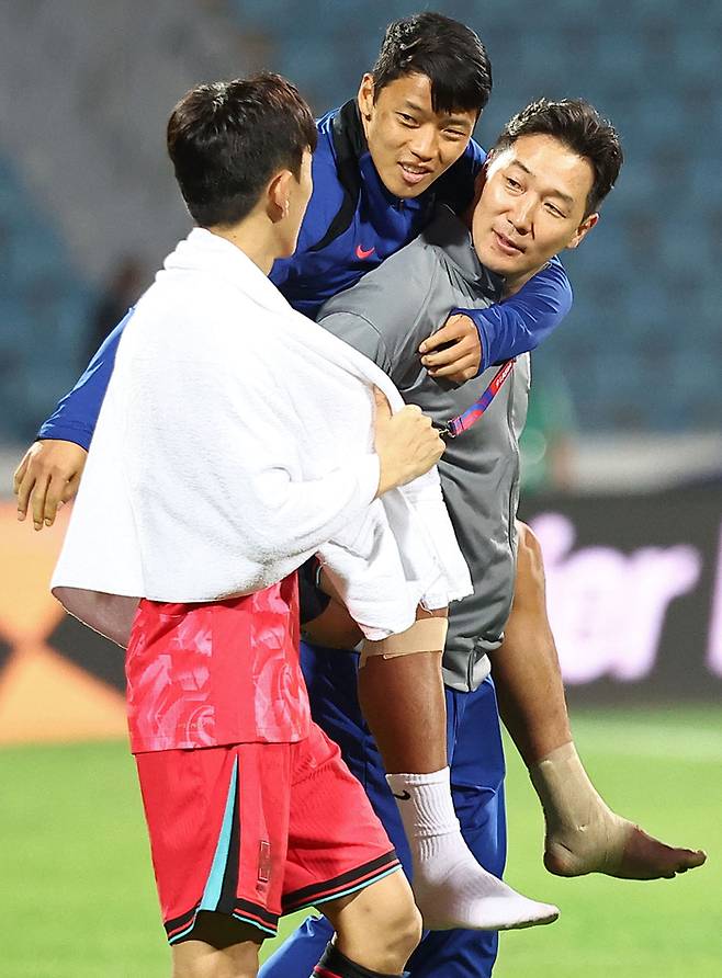 황희찬(가운데 위쪽)이 10일(한국시간) 요르단 암만국제경기장에서 열린 2026 피파 북중미월드컵 아시아 3차 예선 요르단전에서 관계자 등에 업혀 황인범과 이야기를 하고 있다. 사진 | 암만=연합뉴스