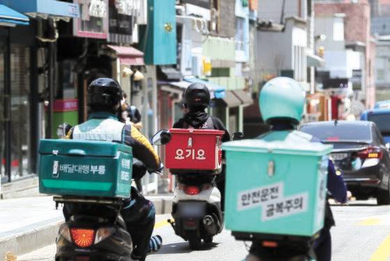 일각에선 공공 배달 앱 활성화를 위해 정부가 적극 나서야 한다는 주장이 나오지만 전문가들은 지속할 수 없는 정책이라고 지적한다. 사진은 서울의 한 대학가에 배달 라이더들이 이동하는 모습. 사진 뉴스1고 있다. 농림축산식품부는 신종코로나바이러스 감염증(코로나19) 방역상황을 고려해 배달앱을 활용한 비대면 외식 할인 지원을 우선 시행한다고 밝혔다. 1만원 환급 대상 배달 앱은 배달의민족, 요기요, 쿠팡이츠, 배달특급, 띵똥, 배달의명수, 일단시켜, 어디go, 배달올거제, 위메프오, 먹깨비, PAYCO, 딜리어스, 카카오톡주문하기 등 14개다. 2021.5.24/뉴스1