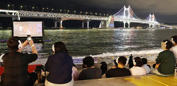 지난 5일 부산 수영구 민락수변공원에서 동네방네비프 일환으로 바다 위 스크린을 통해 영화 ‘30일’이 상영되고 있다. 연합뉴스