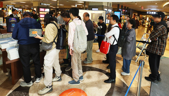 Customers at Kyobo Books' Gwanghwamun branch in Jongno District, central Seoul line up to buy Han Kang's books on Friday, the day after the author's Nobel Prize win. [YONHAP]