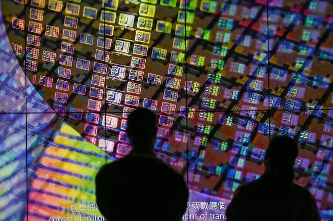 대만 TSMC 혁신 박물관에서 방문객들이 스크린에 표시된 웨이퍼를 보고 있다.(사진=AFP)