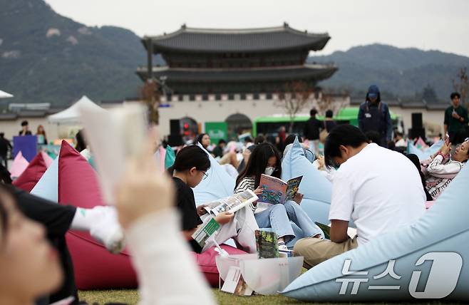 13일 오후 서울 종로구 광화문광장에 마련된 '서울야외도서관 광화문책마당'에서 시민들이 독서 삼매경에 빠져 있다. 한국 최초로 노벨문학상을 받은 작가 한강에 대한 관심과 독서를 '힙하게' 여기는 '텍스트힙'(Text Hip) 트렌드가 맞물려 대한민국 곳곳에 독서 열풍이 거세게 불고 있다. 2024.10.13/뉴스1 ⓒ News1 오대일 기자