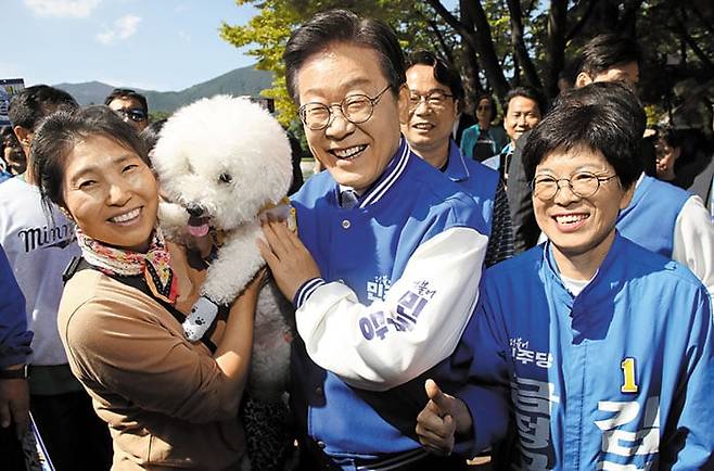 부산 금정 간 이재명 - 더불어민주당 대표가 12일 김경지 부산 금정구청장 후보와 함께 부산 금정구의 한 공원에서 반려견을 안고 있는 시민과 기념사진을 찍고 있다. /뉴스1