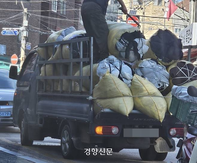 지난달 30일 무등록 개인 수거업자 ‘개미’가 옷 자투리를 옮기고 있다. 이홍근 기자