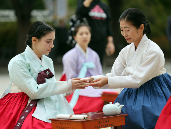 People dressed in hanbok, or traditional Korean clothes, participate in a traditional coming-of-age ceremony at the National Folk Museum of Korea in central Seoul on Monday to celebrate the annual Hanbok Culture Week. The Ministry of Culture, Sports and Tourism will continue to offer diverse hanbok-related exhibitions, experiences and fashion shows through next Sunday. [NEWS1]