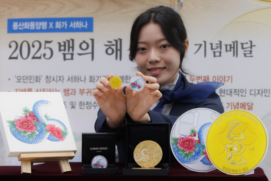 A model presents a commemorative medal for the Year of the Snake in 2025, per the Chinese zodiac calendar, at the the Korea Minting, Security Printing & ID Card Operating Corporation headquarters in Mapo District, western Seoul, on Monday. [YONHAP]