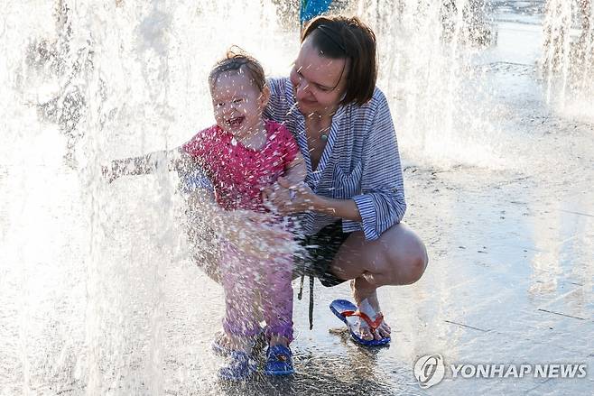 러시아 모스크바서 아기와 분수 즐기는 여성 [타스 연합뉴스 자료사진. 재판매 및 DB 금지]