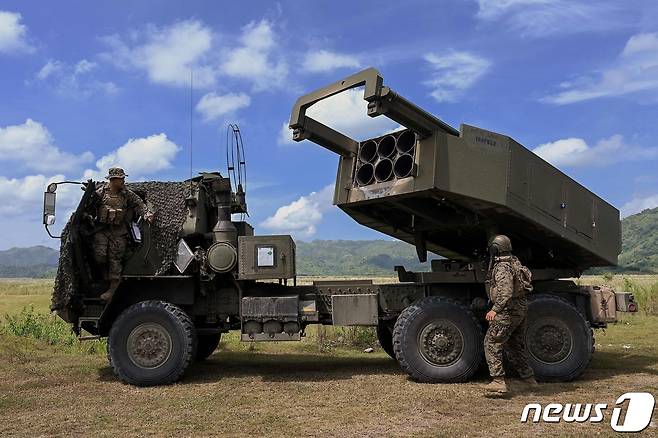 2022 '카만닥'(Kamandag) 연합훈련에 참여한 미 해병대 장교들이 실사격 훈련(CALFEX) 중 M142 고속기동포병로켓시스템(HIMARS·하이마스) 옆에 서 있다. ⓒ AFP=뉴스1 ⓒ News1 한병찬 기자