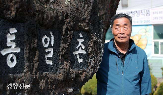 민통선 안에 위치한 경기 파주시 통일촌의 이완배 이장이 지난 9일 1972년 마을이 조성될 때 세워진 기념석 앞에서 사진을 찍기 위해 포즈를 취하고 있다. 오물 풍선과 대남방송에 고통받아온 이 마을 주민들은 북한이 경의선·동해선 연결도로를 폭파한 15일 군의 이동 자제 권고 조치까지 받았다. 서성일 선임기자