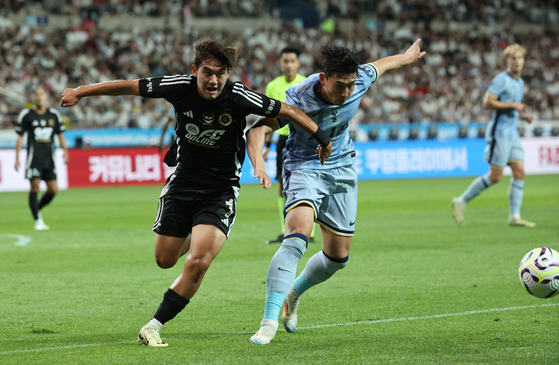 Team K League's Yun Do-yong, left, vies for the ball with Tottenham Hotspur captain Son Heung-min during a Coupang Play Series match at Seoul World Cup Stadium in western Seoul on July 31. [YONHAP]