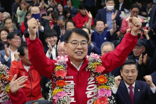 윤일현 국민의힘 금정구청장보궐선거 후보가 16일 오후 부산 금정구 선거사무소에서 당선이 유력해지자 꽃다발을 걸고 환호하고 있다. 연합뉴스