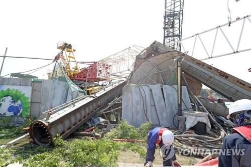 지난 2022년 경북 포항의 한 건설 현장에서 크레인이 넘어져 작업자들이 현장을 정리하고 있다. [연합뉴스 자료사진]