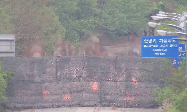 15일 북한이 경의선·동해선 남북 연결도로를 폭파하는 순간 가림막 뒤로 연기와 불꽃이 보인다. 국방부 제공