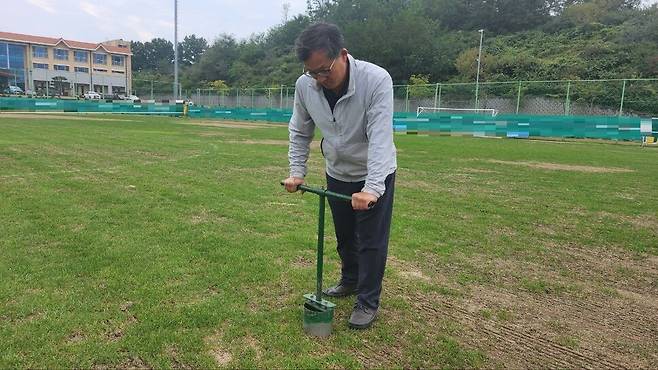 잔디 관리·시공업체인 왕산그린의 이강군 대표가 국내 한 프로축구 구단 연습 구장의 잔디 상태를 확인하고 있다.