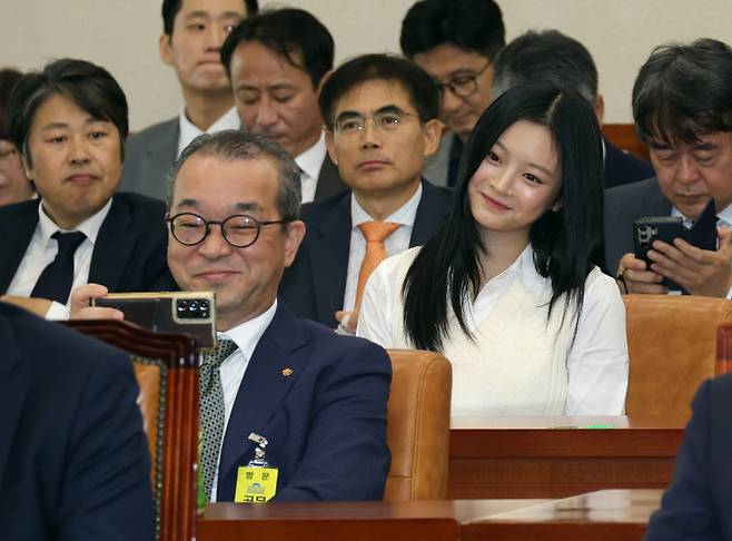 정인섭 한화오션 대외협력실장이 15일 환경노동위원회 국정감사에서 뉴진스 하니와 미소를 지으며 셀카를 찍고 있다. 국회사진기자단