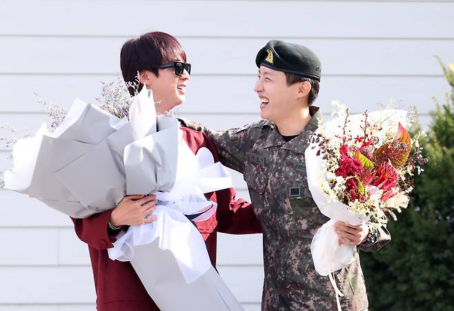 BTS member Jin, left, greets his bandmate J-Hope as the latter finishes his military duty on Oct. 17 in Wonju, Gangwon. [YONHAP]