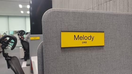 An employee's English name written above their Korean one on a desk divider at KakaoBank [KAKAOBANK]