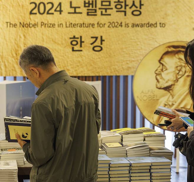 16일 오전 서울 종로구 교보문고 광화문점을 찾은 시민들이 노벨문학상을 수상한 한강의 작품들을 고르고 있다. [사진 출처 = 연합뉴스]