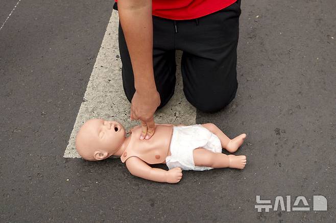 [부쿠레슈티=AP/뉴시스] 16일(현지시각) 루마니아 부쿠레슈티에서 세계 심폐소생의 날을 기념하는 플래시몹이 열려 루마니아 적십자 대원이 어린아이 마네킹을 이용해 아이를 위한 심폐소생술(CPR)을 하고 있다.  10월 16일은 '세계 심폐소생의 날'로 응급상황을 대비해 많은 사람이 CPR을 배울 수 있게 교육해야 한다는 취지로 제정됐다. 미국심장협회는 그룹 '비지스'의 히트곡 '스테잉 얼라이브'를 CPR 시행 시 리듬 맞추기 좋은 노래로 선정한 바 있다. 2024.10.17.