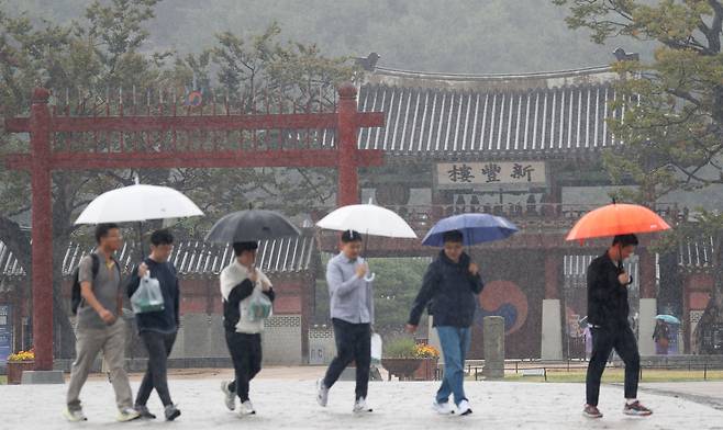 18일 경기 수원시 팔달구 화성행궁 광장에서 시민들이 우산을 쓰고 걷고 있다. /뉴스1