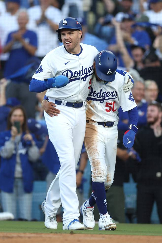 <yonhap photo-2385=""> 14일 NLCS 1차전에서 득점 후 무키 베츠(오른쪽)의 부축을 받은 프레디 프리먼. AFP=연합뉴스</yonhap>