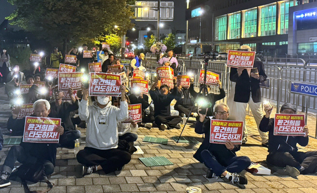 “윤건희 타도” 연좌시위… 17일 오후 서울 용산구 대통령실 앞에서 열린 ‘윤석열 탄핵 용산 평화촛불’ 집회에서 참석자들이 ‘윤건희를 타도하자’는 손팻말을 들고 구호를 외치고 있다.   김유진 기자