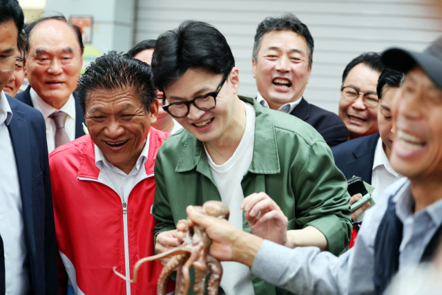 한동훈 국민의힘 대표가 18일 오전 전남 곡성기차마을전통시장에서 상인이 건넨 낙지를 보고 웃고 있다. 연합뉴스