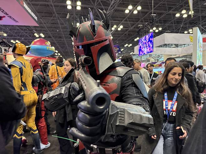 뉴욕 코믹콘 2024 행사를 찾은 뉴요커들 (뉴욕=연합뉴스) 이지헌 특파원 = 17일(현지시간) 미국 뉴욕에서 개막한 '뉴욕 코믹콘(NYCC) 2024' 행사장에서 스타워즈 시리즈에 등장하는 만달로리안 현상금 사냥꾼 캐릭터 복장의 참가자가 포즈를 취하고 있다. 2024.10.17 pan@yna.co.kr