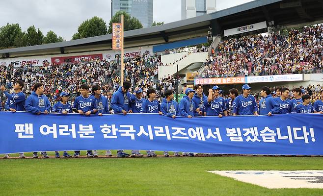 삼성 라이온즈 선수들이 19일 서울 잠실야구장에서 열린 2024 신한 SOL뱅크 KBO 포스트시즌 플레이오프 4차전 LG 트윈스와 경기에서 승리를 거둔 뒤 현수막을 들고 있다. 연합뉴스