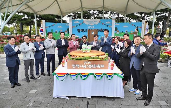 평택시 음식문화축제에서 정장선 평택시장 등 참석자들이 지름 1.2m 크기로 제작된 대형 햄버거를 관람하고 있다. [사진제공=평택시]